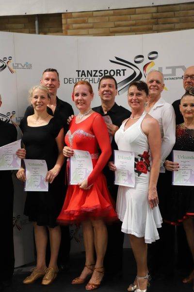 Ein Paar tanzt in eleganter Kleidung auf einer Tanzveranstaltung.