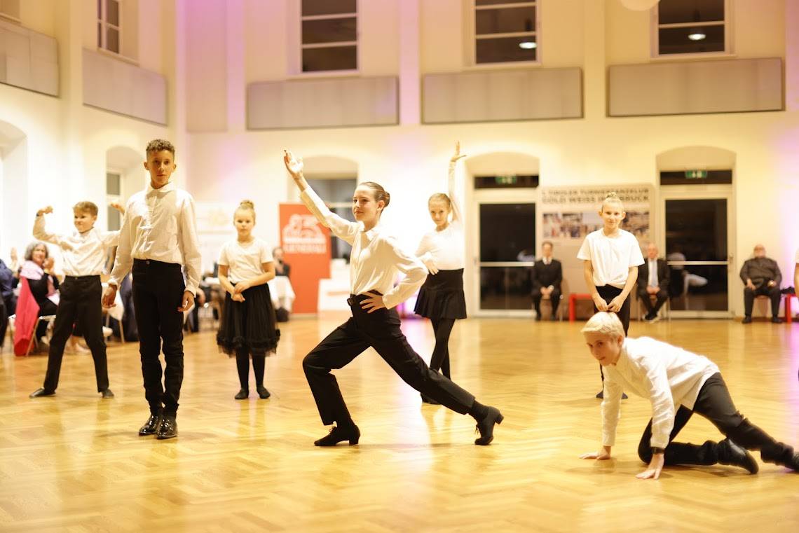 Eine Gruppe von Kindern führt einen Tanzauftritt in einem festlichen Raum auf.