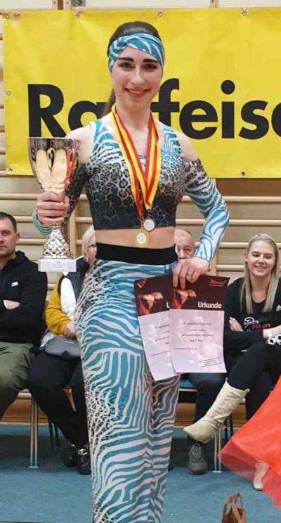 Eine Gruppe von Tänzern steht auf einem Podium, wobei die besten drei Teilnehmer bei einem Tanzwettbewerb ausgezeichnet werden.